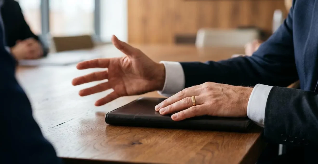 Close-up of hands presenting structured financial recovery framework in controlled board meeting setting