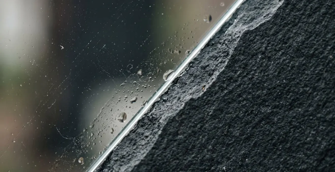 Extreme macro detail of transparent glass surface meeting opaque material symbolizing transparency versus concealment